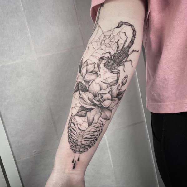 Scorpion on spider web with lotus and skeleton