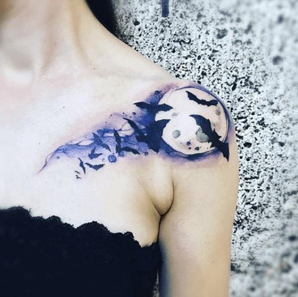 Watercolor bats and moon tattoo on shoulder