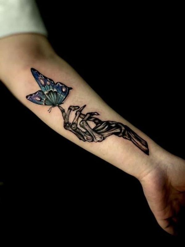 A skeleton hand touching a butterfly