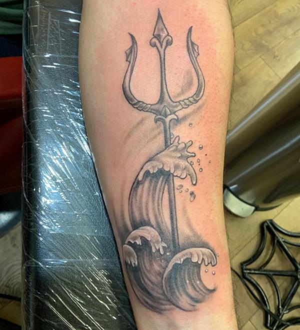 Black and grey Trident in wave tattoo