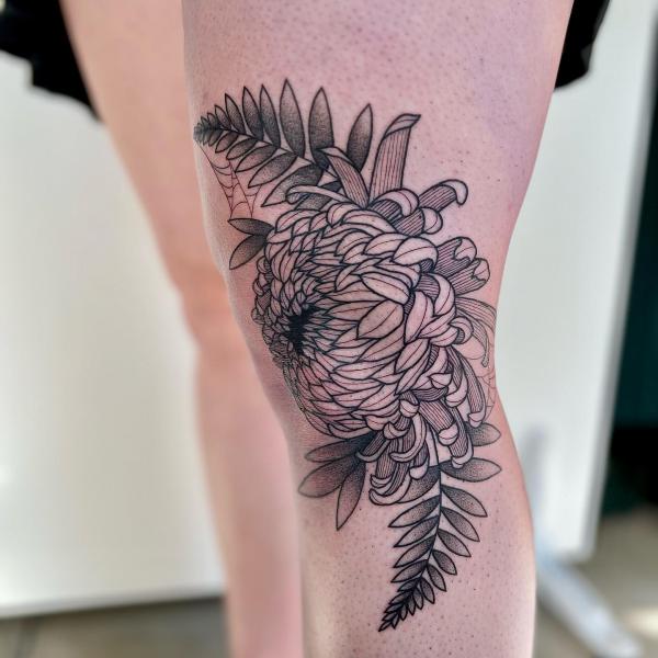 Chrysanthemum line work tattoo on the knee