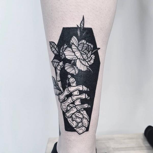 Coffin silhouette with skeleton hand and rose
