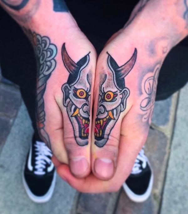 Oni mask finger tattoo