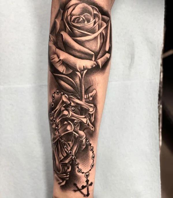 Skeleton hand and rose forearm tattoo