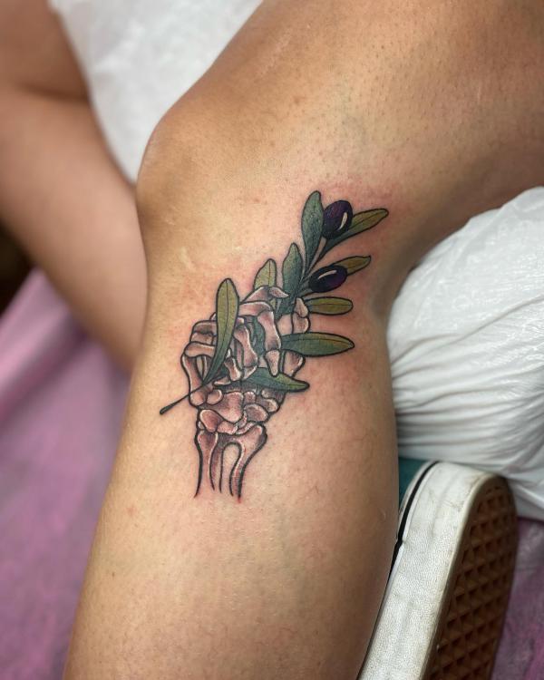 Skeleton hand holding olive branch