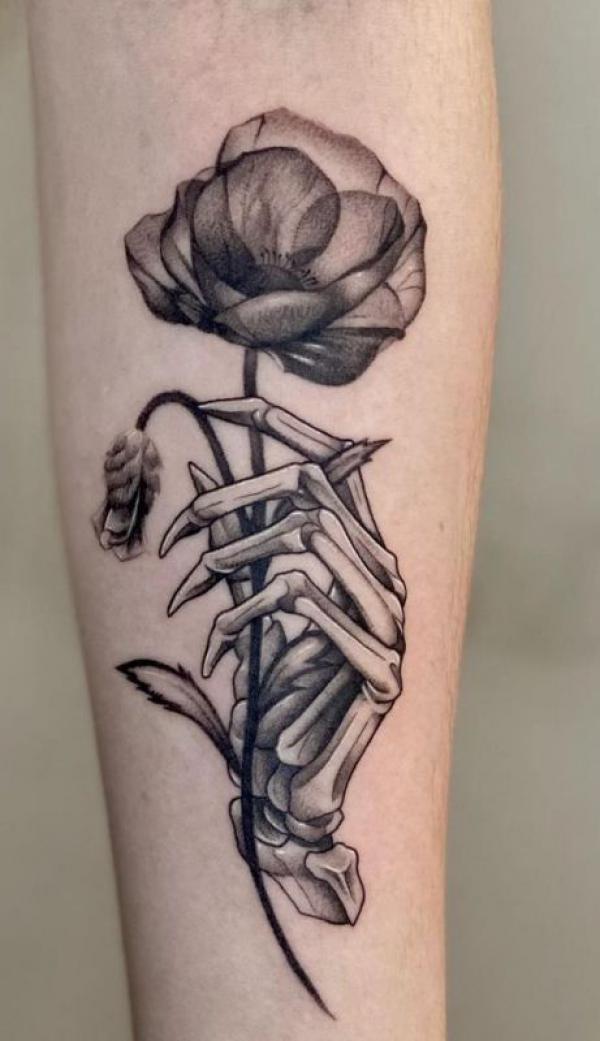 Skeleton hand holding poppy