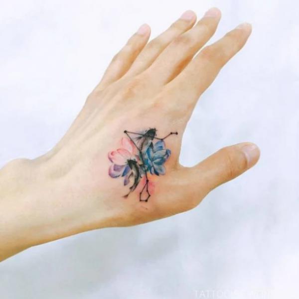 Water lily and Pisces constellation hand tattoo