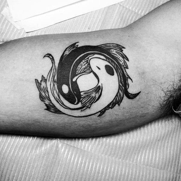 Yin Yang pisces fish bicep tattoo