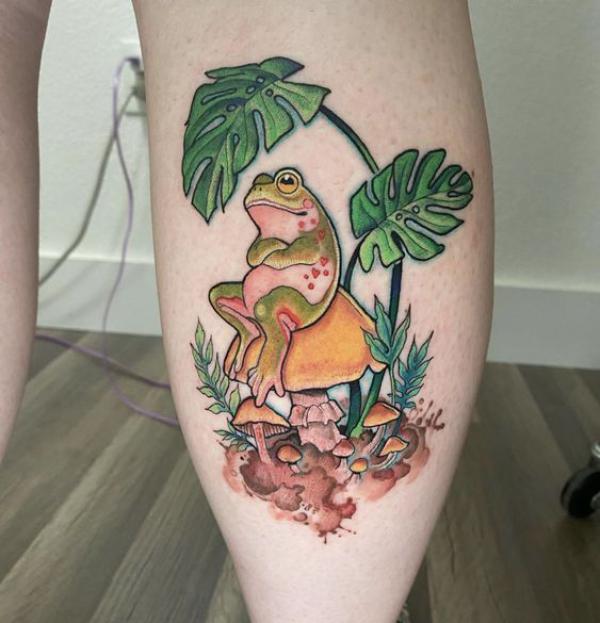 A frog sitting on mushroom under leaf