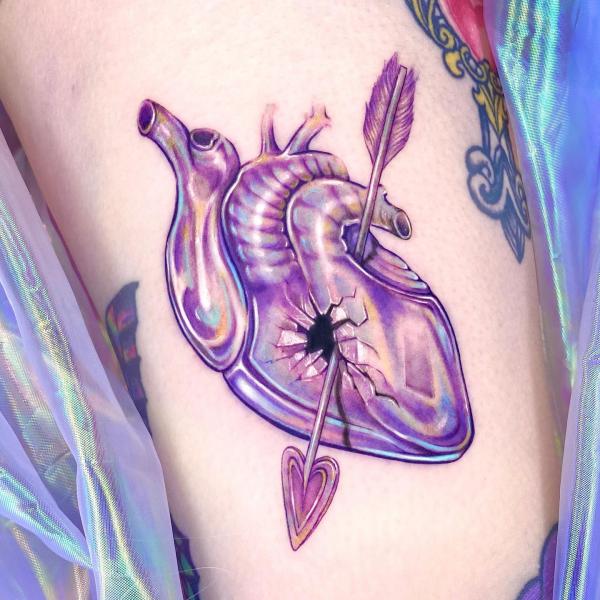 A tattoo of an arrow through a human heart
