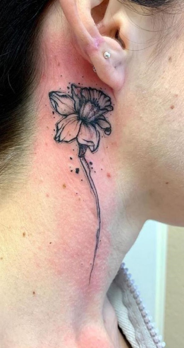 Black and grey daffodil tattoo behind ear