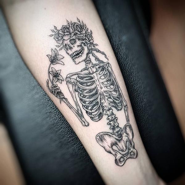 Black and grey skeleton with flower crown holding lily flowers