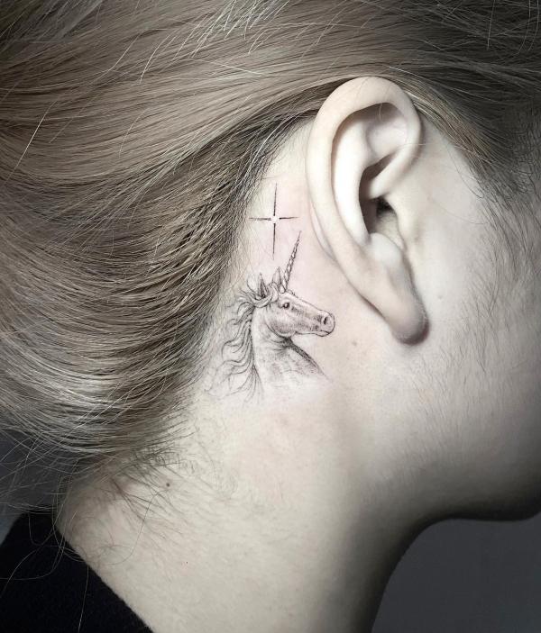 Black and grey unicorn tatto behind ear