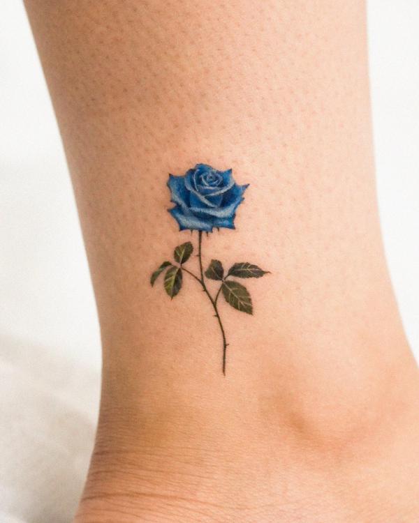Small blue rose tattoo on the ankle.