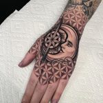 Moon face and compass rose surrounded with flower of life pattern