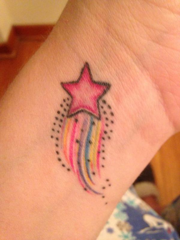 Rainbow shooting star wrist tattoo