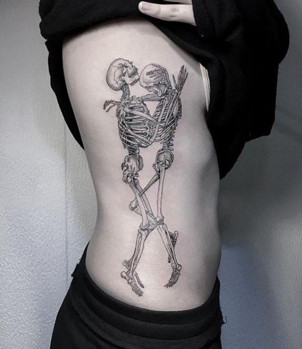 Two hugging skeletons side tattoo