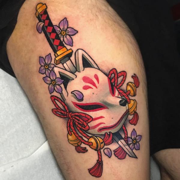 A dagger pierced kitsune mask thigh tattoo