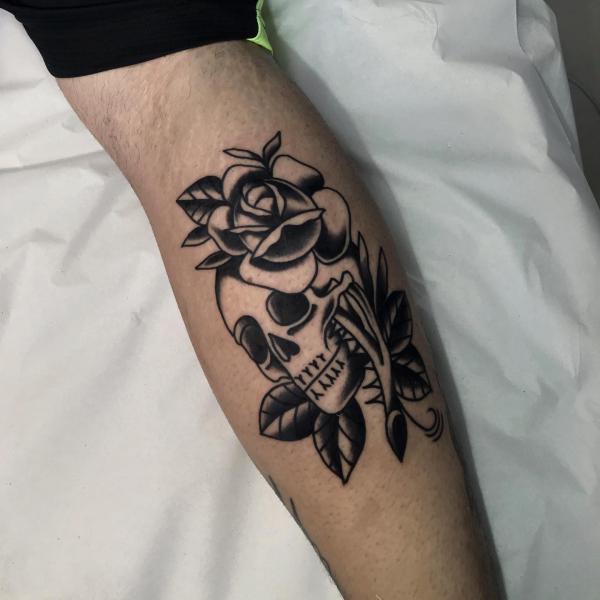 A dagger pierced the skull adorned with a rose