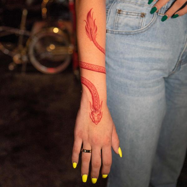A red dragon wrapped around the forearm