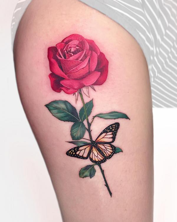 A stem of red rose and monarch butterfly tattoo