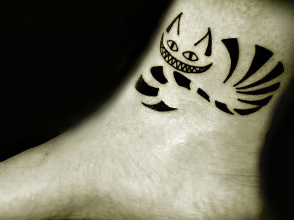 Black Ink Cheshire Cat ankle tattoo