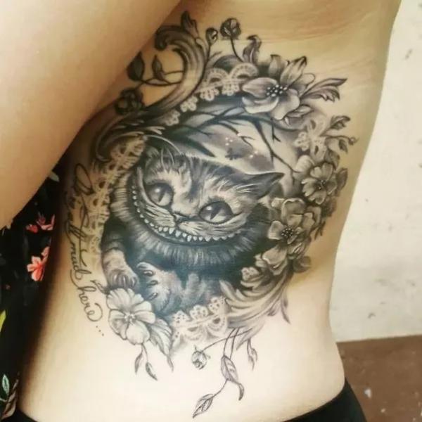 Black and grey Cheshire Cat side tattoo
