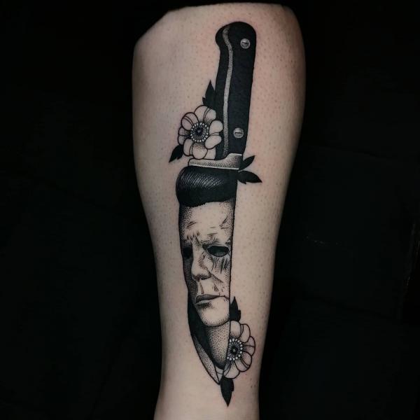 Black and white knife with Michael Myers face and flowers tattoo