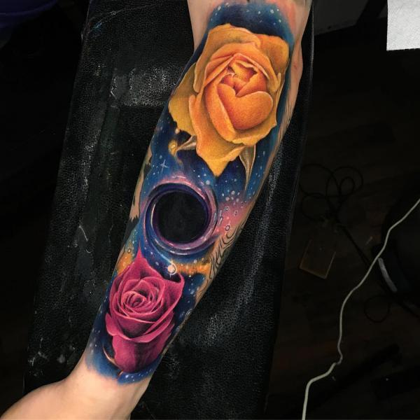 Black hole in galaxy with red and yellow rose tattoo