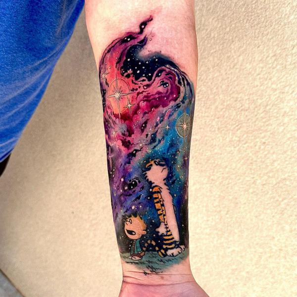 Calvin and Hobbes in galaxy forearm tattoo