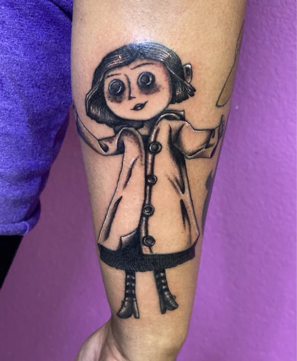 Coraline tattoo on outer forearm