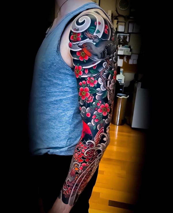 Japanese cherry blossom tree with a bird tattoo sleeve