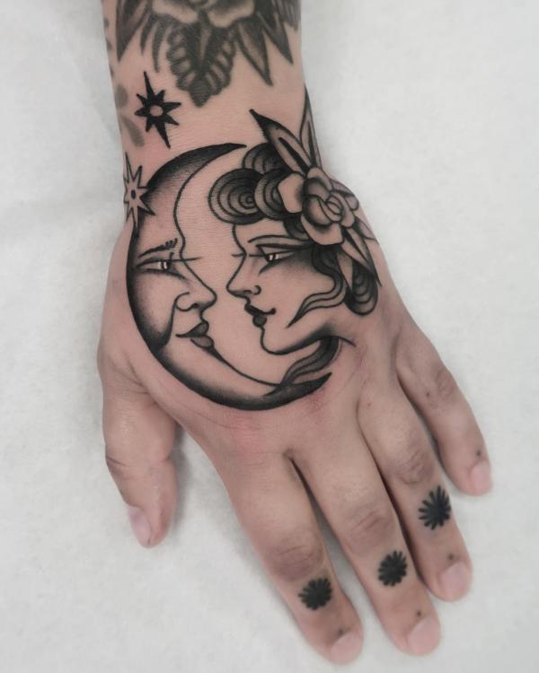 Moon and female faces hand tattoo