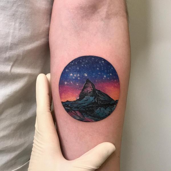 Mountain and galaxy circle tattoo