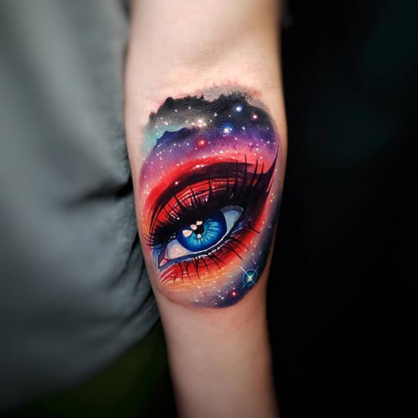 Realistic eye with galaxy mountain range tattoo