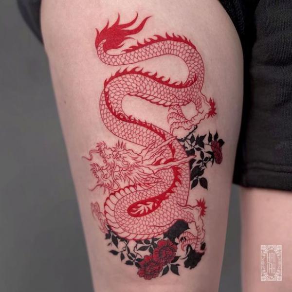 Red dragon and flower tattoo on thigh
