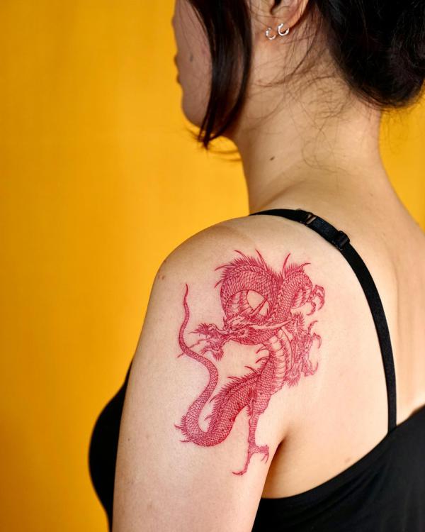 Small red dragon inked on shoulder