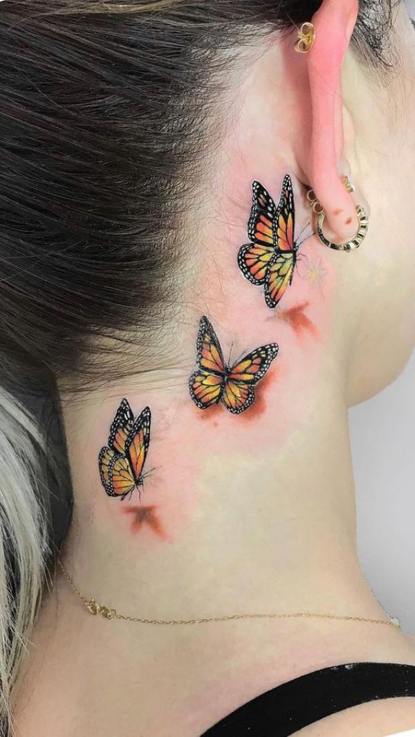 Three Monarch butterflies on the side of neck