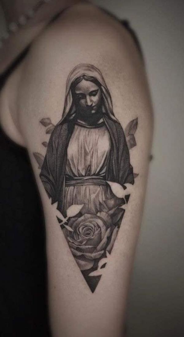 Minimalist Virgin Mary tattoo on the wrist.