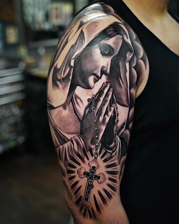 Virgin Mary with praying hands tattoo