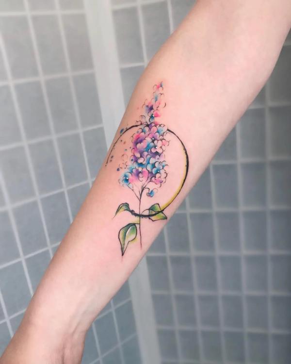 Watercolor lilac tattoo on forearm