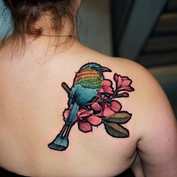 A bird perched on a branch of flower