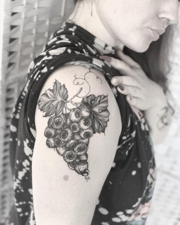 A bunch of grapes shoulder tattoo black and grey
