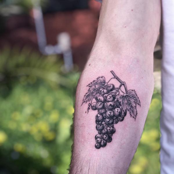 A bunch of grapes tattoo under inner elbow black and grey