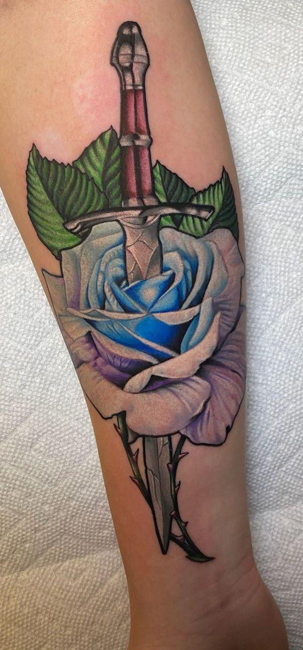 A dagger pierced a blue and pink rose tattoo