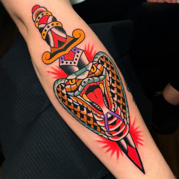 A dagger pierced cobra head tattoo