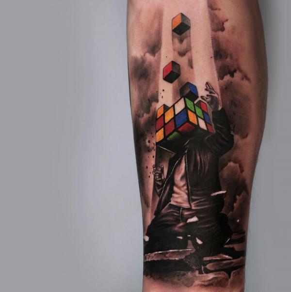 A kneeling man with a head of Rubiks Cube