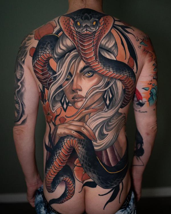 A large cobra wrapping around a female full back tattoo