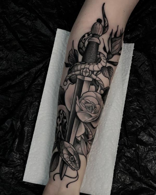 A snake wrapping around dagger with rose tattoo