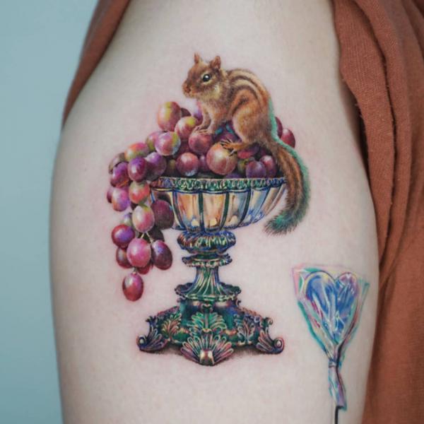 A squirrel on grapes in goblet bowl